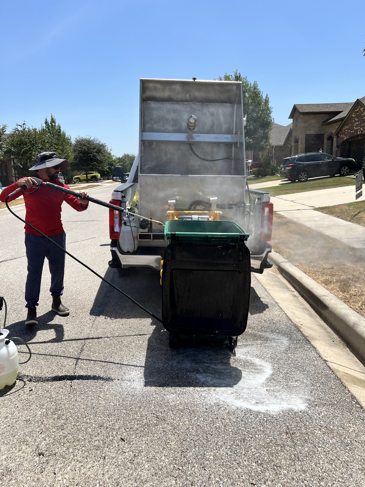 Keep Bin Clean technician working beside the service truck for Lucy Thompson